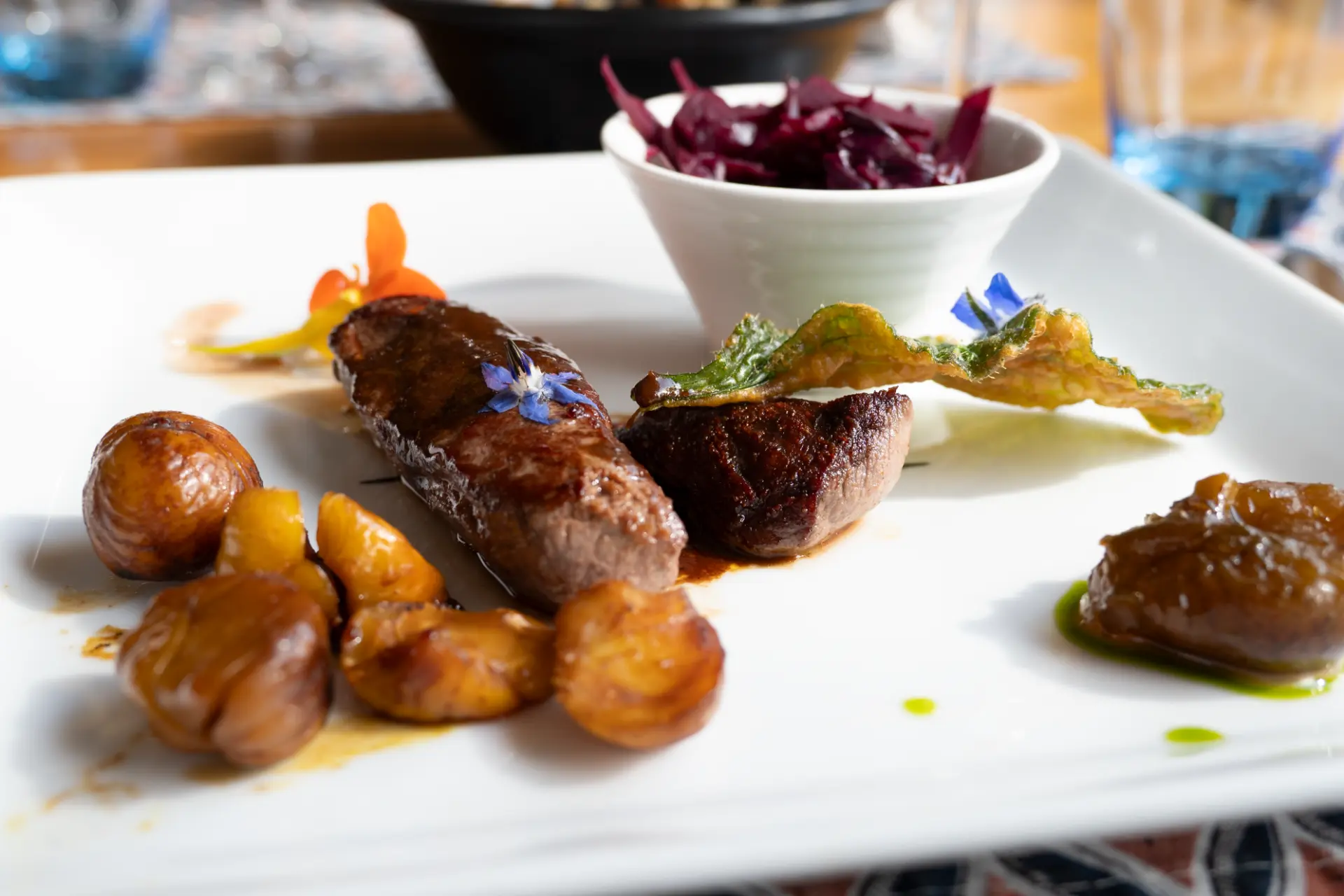 Assiette de chasse avec viande, marrons, chou rouge et garnitures de saison
